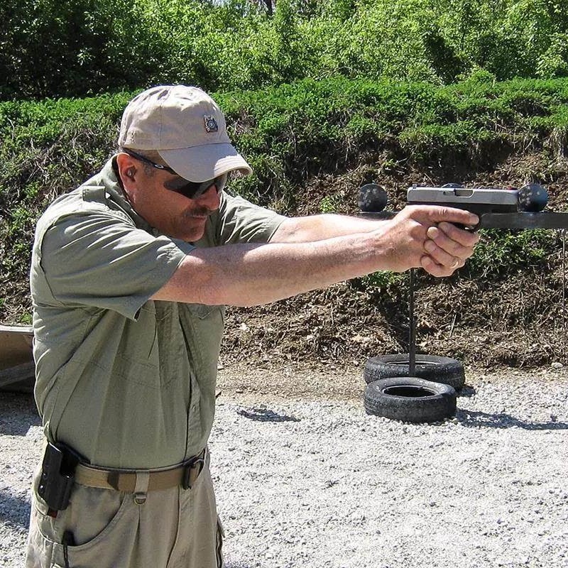 when firing a handgun how far from the body